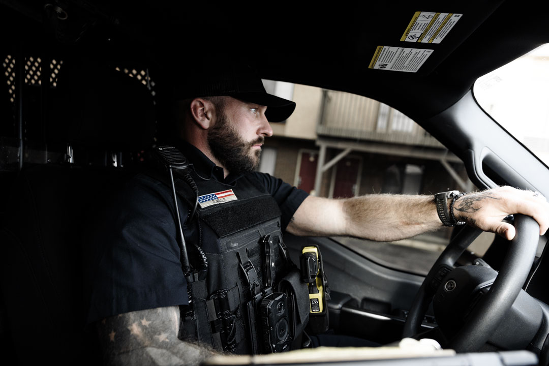 Law enforcement officer wearing the Angel Armor Patrol Carrier 2.0 while driving a patrol vehicle, showing fit, comfort, and duty-ready performance