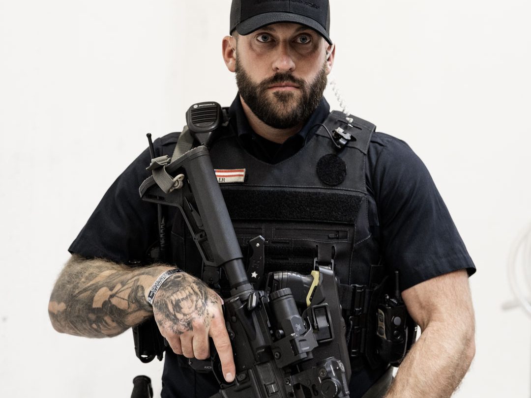 Officer gripping rifle in a ready position while wearing the Patrol Carrier 2.0, highlighting the carrier’s clean profile, equipment integration, and operational stability.
