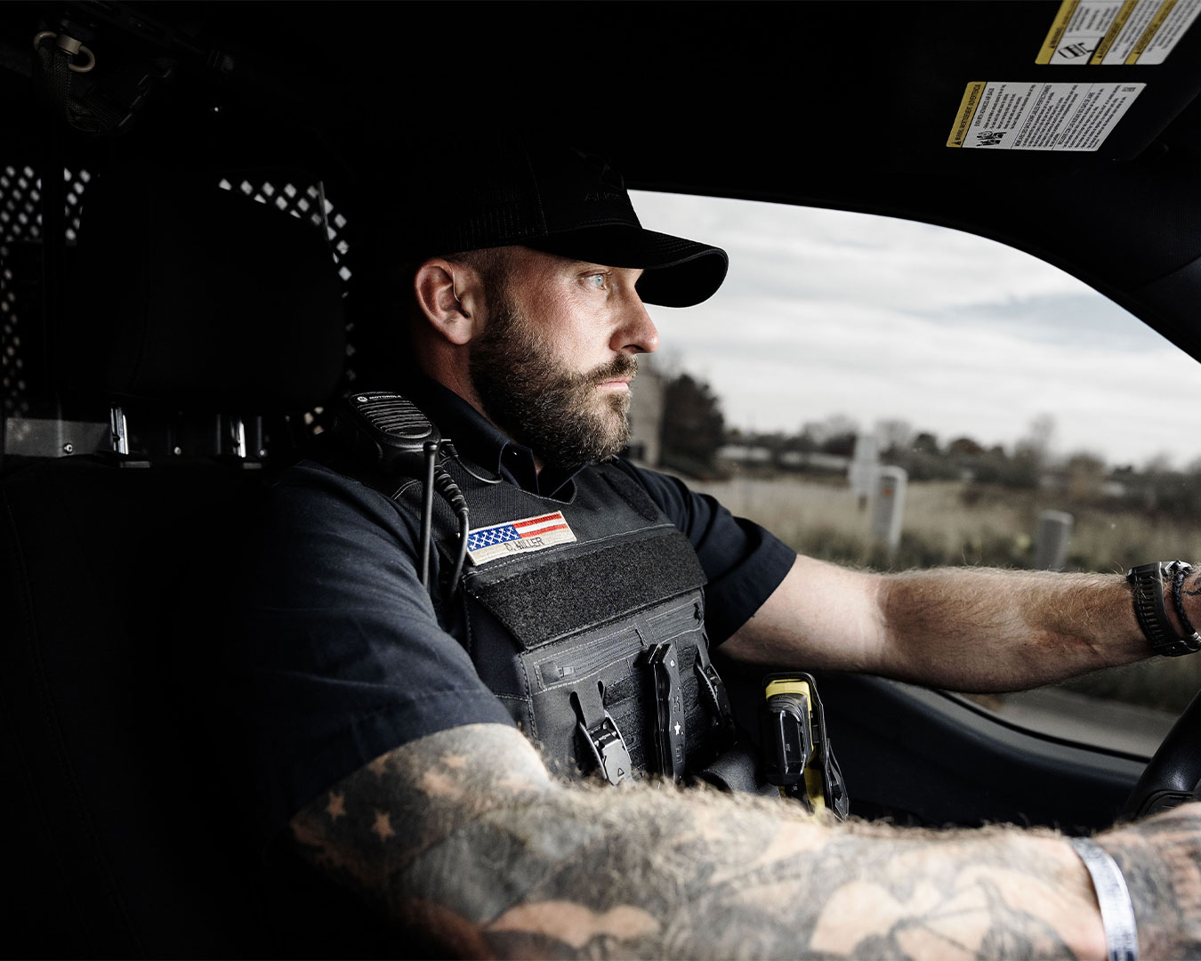 Law enforcement officer wearing the Angel Armor Patrol Carrier 2.0 while driving a patrol vehicle, showing fit, comfort, and duty-ready performance
